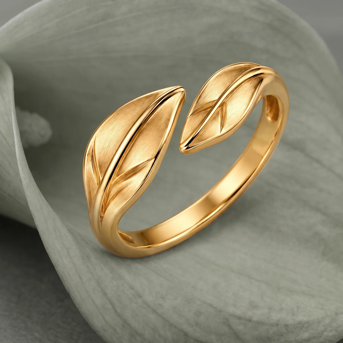 AI visualization: Open double-leaf gold ring on a muted sage petal